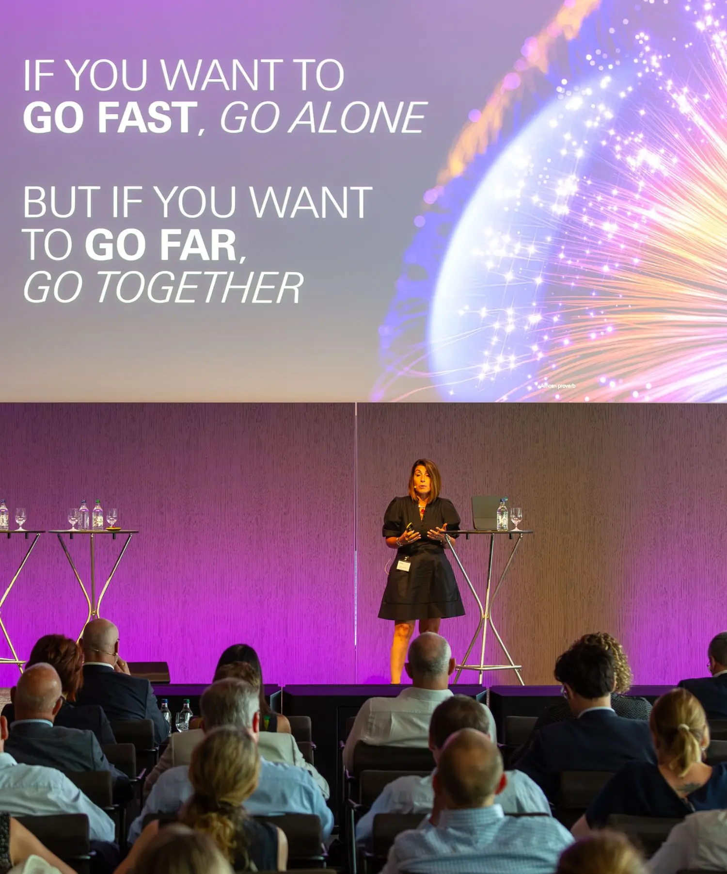 Female standing in the stage and presenting on the event