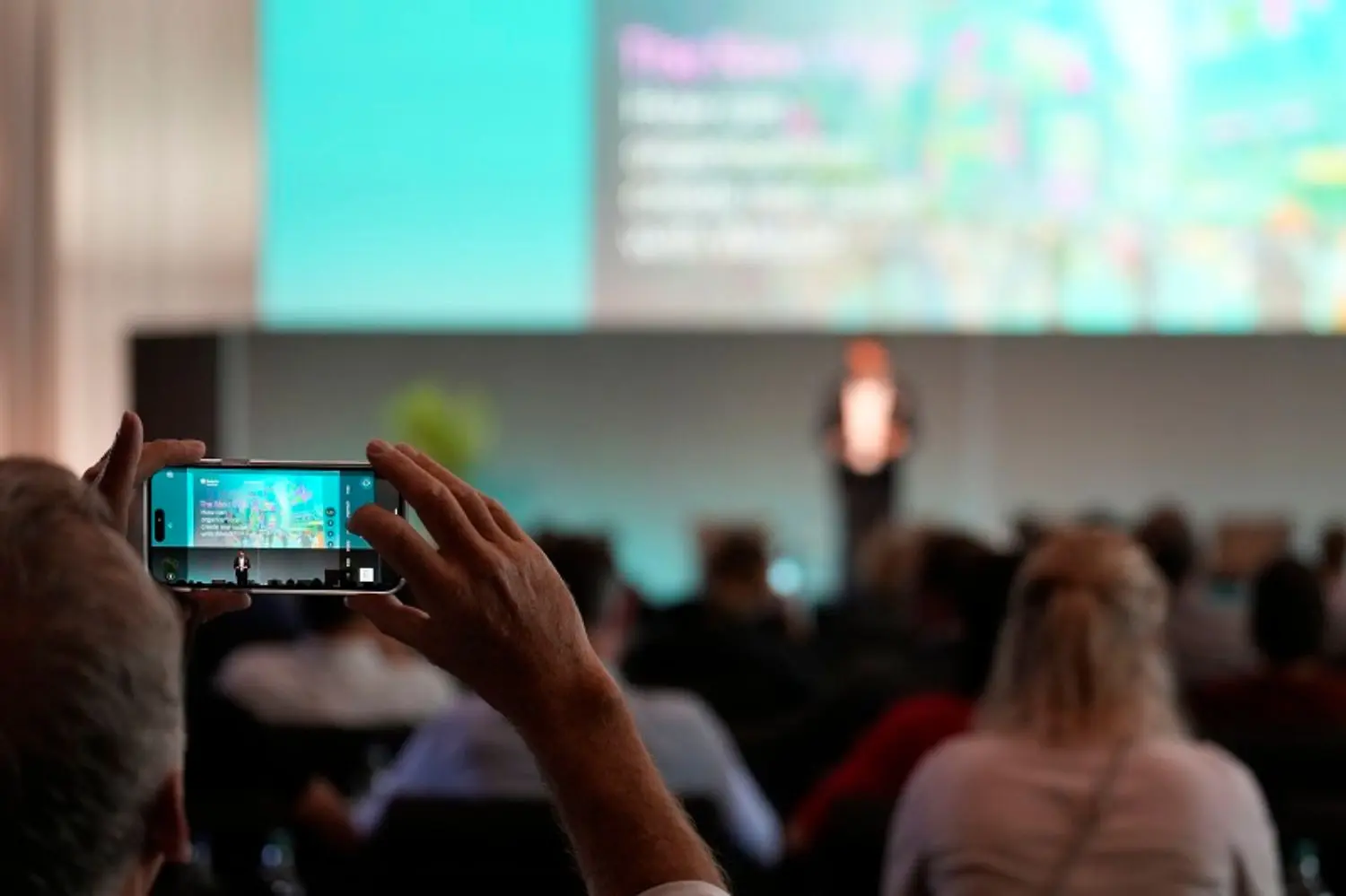 A person taking a video of a presentation at The Next Web conference.