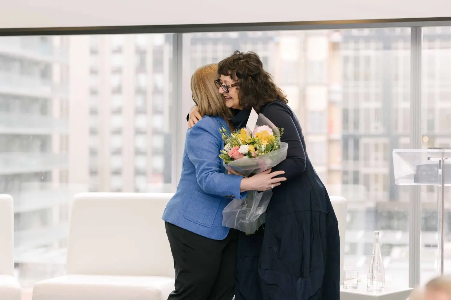 Photo from 37th annual Canadian Insurance Outlook Breakfast: women hugging.